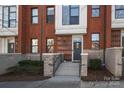Charming brick townhome featuring concrete steps, an ADT security system, and inviting landscaping at 530 N Mcdowell St, Charlotte, NC 28204