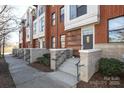 Brick townhomes featuring concrete steps with black rails and well-maintained landscaping at 530 N Mcdowell St, Charlotte, NC 28204