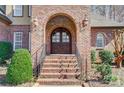 Elegant front entrance with brick archway, wooden doors and manicured landscaping at 6548 Robin Hollow Dr, Mint Hill, NC 28227