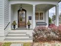 Inviting front porch with hanging lantern, porch swing, and an arched front door at 700 Clement Ave, Charlotte, NC 28204