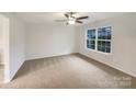 This is an empty bedroom freshly painted with a big window and a ceiling fan with light. New carpet has been installed at 845 Finley Rd, Rock Hill, SC 29730