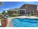 Backyard featuring a uniquely shaped swimming pool, a patio with furniture, and an artful garden at 100 Cliveden Ct, Belmont, NC 28012