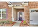 Inviting front entryway with a decorative wreath, brick facade, and manicured landscaping at 10014 Berkeley Castle Dr, Charlotte, NC 28273