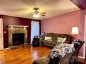 Cozy living room featuring a stone fireplace, hardwood floors, and comfortable seating at 105 Old Bridge Ct, Gastonia, NC 28056