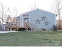 Inviting single-story home showcasing a cozy wooden deck and well-maintained lawn with charming decorative stars at 1514 Robin Rd, Newton, NC 28658
