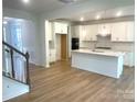 Bright kitchen with island, white cabinets, stainless appliances, hardwood flooring, and lots of natural light at 177 Glenn Dr, Mooresville, NC 28115