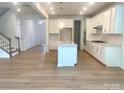 Bright kitchen with island, white cabinets, stainless appliances, hardwood flooring, and lots of natural light at 177 Glenn Dr, Mooresville, NC 28115