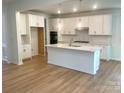 Bright, open kitchen boasts white cabinetry, a large island, and stainless steel appliances at 177 Glenn Dr, Mooresville, NC 28115