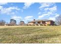Spacious front yard showcasing a traditional brick home with covered porch on a sunny day at 290 S Enochville Ave, Kannapolis, NC 28081