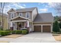 A stately exterior view, with a front porch, and a two-car garage provides ample parking and storage at 3439 Richards Xing, Fort Mill, SC 29708