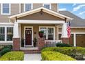 Inviting front porch with brick accents, white pillars, and decorative plants framing the entry at 3439 Richards Xing, Fort Mill, SC 29708