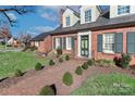 Stunning brick home entrance with lush green landscaping, a brick walkway, and a welcoming green door at 632 N Oakland Ave # Pt1, Statesville, NC 28677