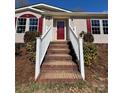 Inviting front entrance with brick steps, white railings, and a vibrant red front door at 110 Amber Ln, Statesville, NC 28677