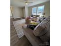 Bright living room featuring hardwood floors, neutral paint, and natural light from large windows at 110 Amber Ln, Statesville, NC 28677