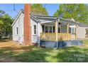View of the side and front of the house showing the small porch and brick chimney at 112 Courtland St, Chester, SC 29706
