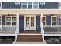 Inviting front porch with double doors, stylish lighting, and plenty of space for relaxing at 117 Mills Garden Rd, Statesville, NC 28625