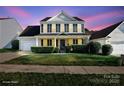 Attractive two-story home with manicured front lawn and traditional architectural details under a colorful sky at 11711 Royal Castle Ct, Charlotte, NC 28277