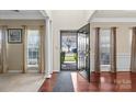 Elegant foyer showcasing gleaming hardwood floors, decorative columns, and abundant natural light at 11711 Royal Castle Ct, Charlotte, NC 28277