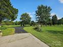 Long driveway leading to a home with a well-maintained lawn and mature trees at 130 Scism Rd, Kings Mountain, NC 28086