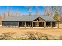 Beautiful modern farmhouse with dark siding, a covered porch, and a dormant lawn at 13546 W Highway 55 W Hwy, York, SC 29745