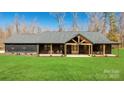 Beautiful modern farmhouse with dark siding, a covered porch, and a well-manicured lawn at 13546 W Highway 55 W Hwy, York, SC 29745