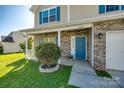 Inviting front entrance featuring a brick facade, blue door, and a meticulously landscaped yard at 1612 Beleek Ridge Ln, Clover, SC 29710