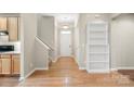 Bright entryway featuring hardwood floors, staircase, and a built-in bookshelf at 2009 Whippoorwill Ln, Indian Trail, NC 28079