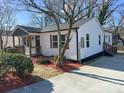 Well-maintained home with white siding, front porch, landscaped yard, and convenient driveway at 226 Malvern Sw Dr, Concord, NC 28025