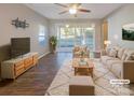Bright, staged living room with a neutral color palette, large windows, and sliding glass doors to the backyard at 23186 Goose Down Ln, Lancaster, SC 29720