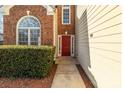 Inviting front entrance with a red door, decorative sidelights, and manicured bushes at 3203 Arklow Rd, Charlotte, NC 28269