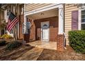 Inviting covered porch with brick columns and patriotic American flag display at 8422 Chaceview Ct, Charlotte, NC 28269