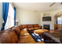 Cozy living room features a fireplace, hardwood floors, and large windows at 8422 Chaceview Ct, Charlotte, NC 28269