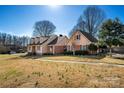 Angle shot of the charming house with lush green lawn and mature trees showcasing its appealing curb appeal at 133 Persimmon Creek Rd # 81, Kings Mountain, NC 28086