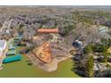 Aerial view of a waterfront home with private dock surrounded by lush greenery and calm waters at 13701 Petworth Ct, Charlotte, NC 28278