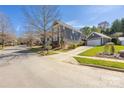Beautiful home exterior with manicured lawn, detached garage and paved driveway on a tree lined street at 13725 Mallory Baches Ln, Huntersville, NC 28078