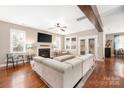 Bright living room featuring a fireplace, plush sofa, hardwood floors, and abundant natural light at 13725 Mallory Baches Ln, Huntersville, NC 28078