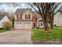 Charming two-story home featuring a two-car garage, red shutters, and a well-manicured lawn at 1452 Deer Forest Dr, Indian Land, SC 29707