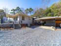This property features a deck, and detached carport area, surrounded by trees at 17118 Frog Pond Rd, Oakboro, NC 28129