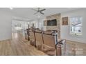 Bright living room with a stone fireplace, modern ceiling fan, and cozy leather seating at 293 Blanche Cir, Rock Hill, SC 29730