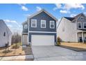 Charming two-story home showcasing a well-manicured lawn and a driveway leading to a two-car garage at 5010 Arbordale Way # 5, Mount Holly, NC 28120