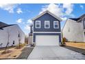 Charming two-story home showcasing a well-manicured lawn and a driveway leading to a two-car garage at 5010 Arbordale Way # 5, Mount Holly, NC 28120
