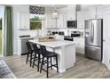 Lovely white kitchen features stainless appliances, center island and breakfast bar at 7200 Hodges Meadow Ln, Charlotte, NC 28213