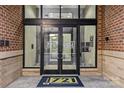 Entrance to building showcasing glass doors, brick walls, and a welcome mat for condominium residents at 721 Governor Morrison St # 408, Charlotte, NC 28211