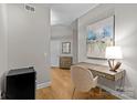 Hallway with hardwood flooring, a desk, and neutral paint that showcases a tranquil living space at 721 Governor Morrison St # 408, Charlotte, NC 28211