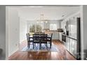 Eat-in kitchen featuring stainless steel appliances, white cabinets, and a sliding glass door to the backyard at 10337 Hugue Way, Charlotte, NC 28214