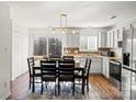 Bright eat-in kitchen with stainless steel appliances, white cabinets, and a tiled backsplash at 10337 Hugue Way, Charlotte, NC 28214