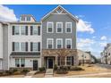 Stylish two-story townhouse showcases a gray exterior, complemented by a well-manicured lawn and inviting front entrance at 1037 Naples Dr, Davidson, NC 28036