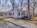 The white exterior with black shutters is accented by a tall brick chimney at 10514 Lorelei Pl, Charlotte, NC 28227