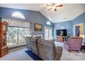 Spacious living room featuring vaulted ceilings, large windows, a fireplace, and comfortable seating at 11010 Pale Hickory Ln, Charlotte, NC 28215