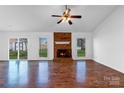 Inviting living room featuring a brick fireplace, ceiling fan, and bright natural light at 12012 Stainsby Ln, Charlotte, NC 28273